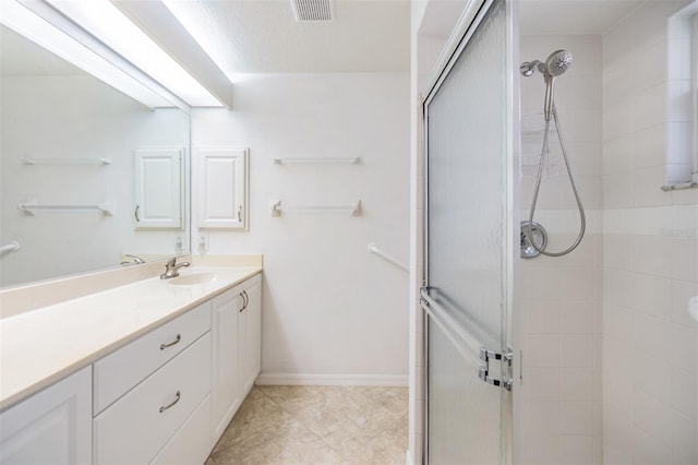 bathroom featuring tile patterned flooring, vanity, and walk in shower