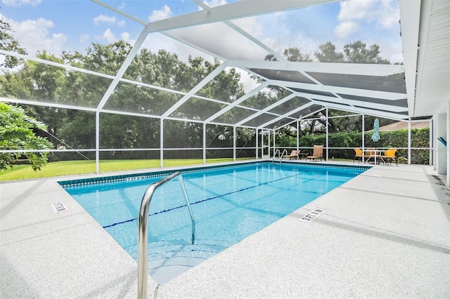 view of pool featuring a lawn, glass enclosure, and a patio area