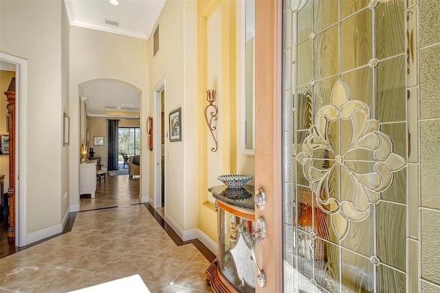 hall featuring light tile patterned floors and crown molding