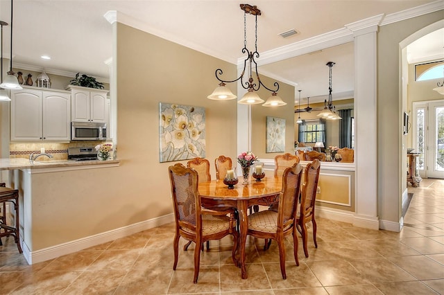 dining space with sink, light tile patterned floors, and ornamental molding