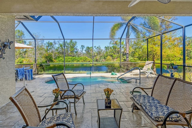 view of patio / terrace featuring a lanai, ceiling fan, and a water view