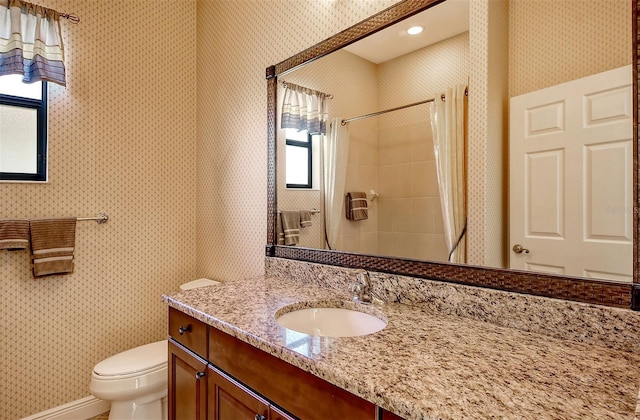 bathroom with vanity, toilet, and curtained shower