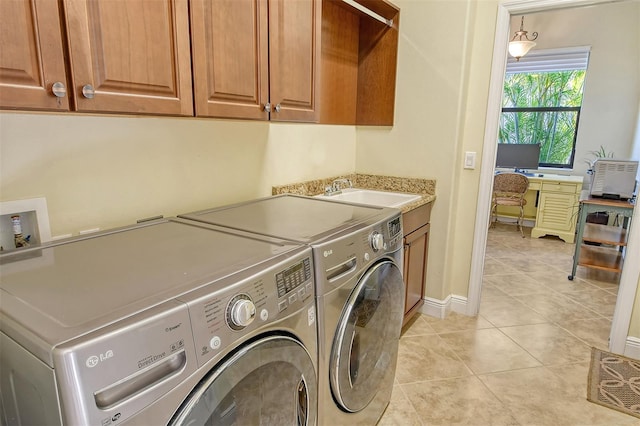 clothes washing area with washer and clothes dryer, light tile patterned flooring, cabinets, and sink