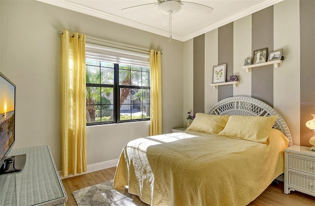 bedroom featuring ceiling fan, crown molding, and light hardwood / wood-style flooring