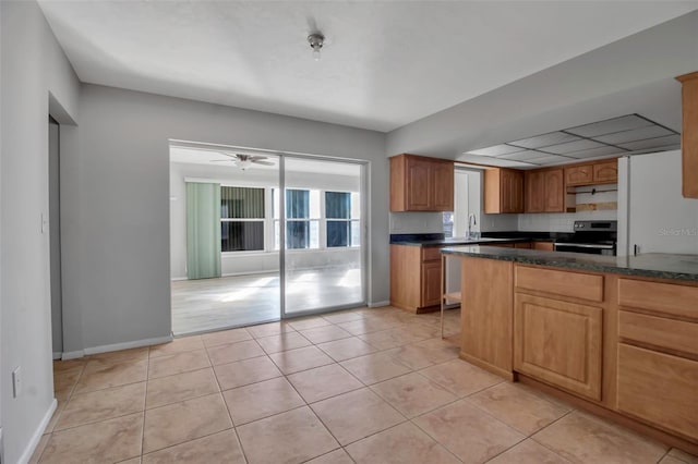 kitchen featuring light tile patterned flooring, appliances with stainless steel finishes, ceiling fan, and sink