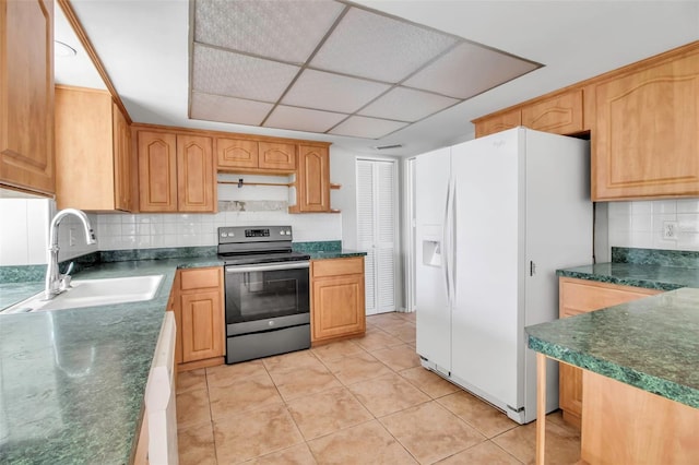 kitchen with sink, a drop ceiling, tasteful backsplash, white appliances, and light tile patterned floors