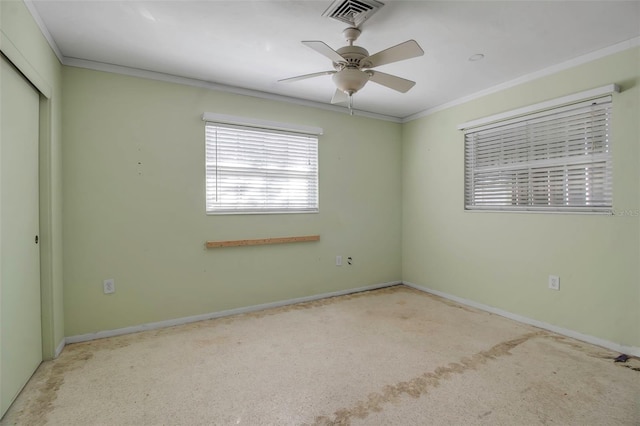 unfurnished bedroom featuring a closet, ceiling fan, crown molding, and light carpet