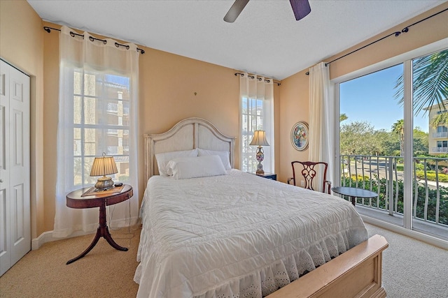 bedroom featuring light colored carpet, multiple windows, and ceiling fan