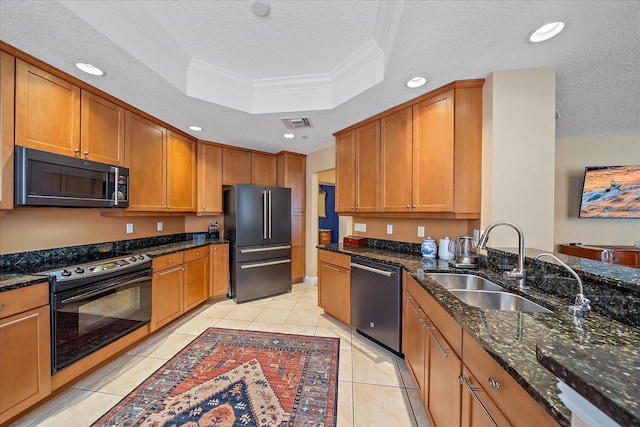 kitchen featuring dark stone countertops, sink, a textured ceiling, and appliances with stainless steel finishes