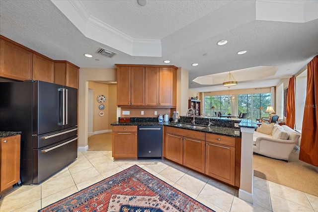 kitchen featuring sink, a textured ceiling, a tray ceiling, high end fridge, and kitchen peninsula