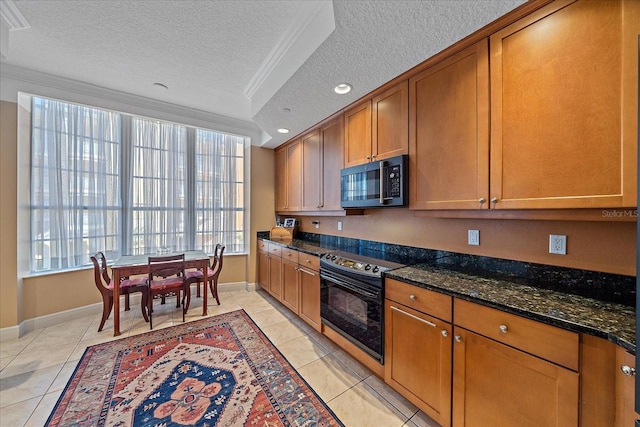 kitchen with dark stone countertops, plenty of natural light, black / electric stove, and a textured ceiling