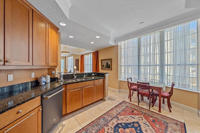 kitchen with dishwasher, dark stone counters, sink, light tile patterned floors, and a textured ceiling