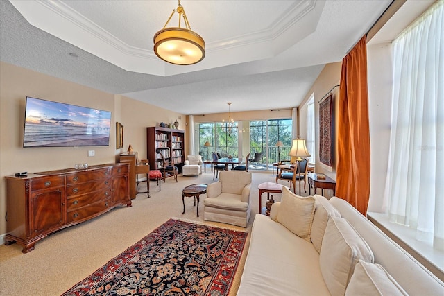 carpeted living room with a raised ceiling, ornamental molding, and a textured ceiling