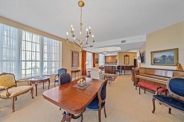 carpeted dining area featuring a chandelier and a textured ceiling