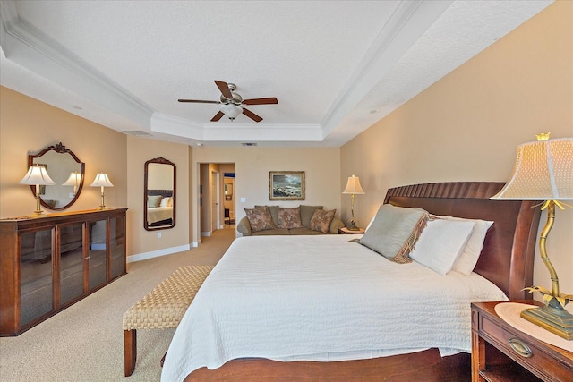 bedroom with crown molding, ceiling fan, a textured ceiling, a tray ceiling, and light colored carpet