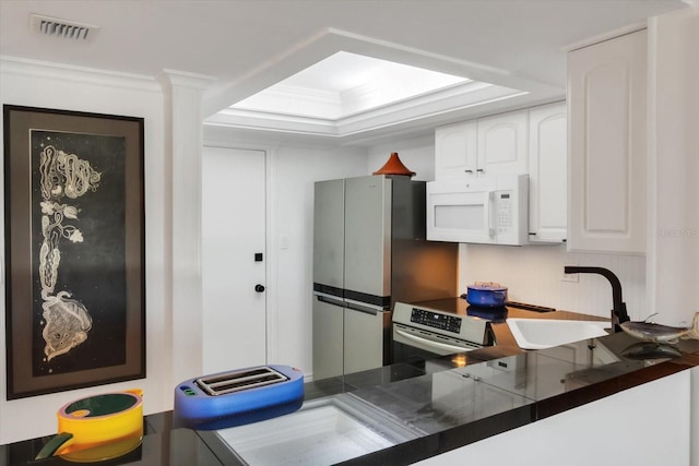 kitchen with sink, crown molding, a tray ceiling, white cabinets, and range