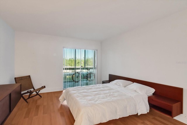 bedroom with access to exterior and light hardwood / wood-style flooring