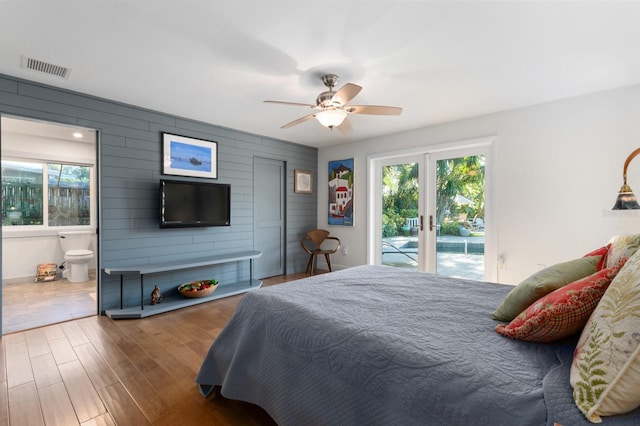 bedroom with french doors, access to outside, ceiling fan, hardwood / wood-style flooring, and wood walls