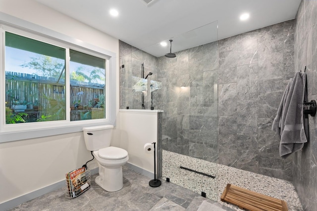 bathroom featuring a tile shower and toilet