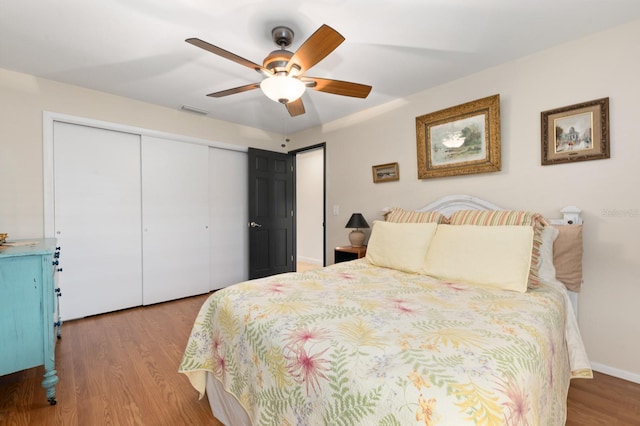 bedroom featuring hardwood / wood-style flooring, ceiling fan, and a closet