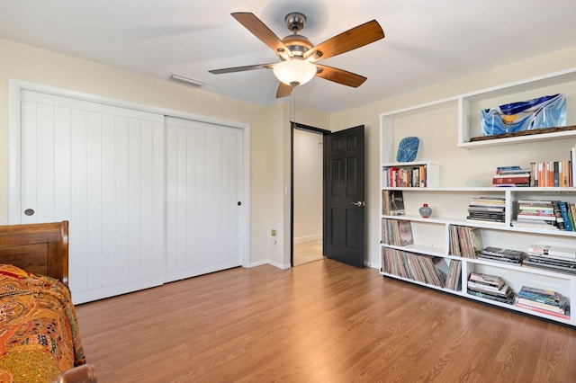 bedroom with a closet, light hardwood / wood-style flooring, and ceiling fan