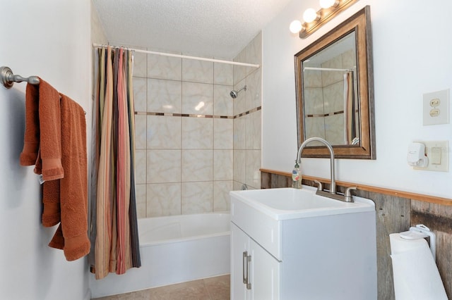 bathroom with tile patterned floors, vanity, a textured ceiling, shower / tub combo with curtain, and wooden walls