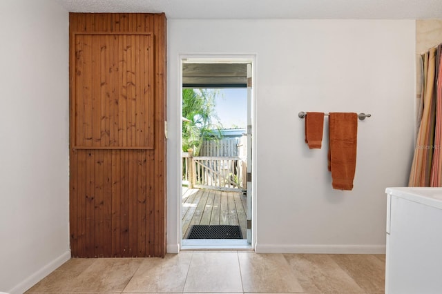 entryway with light tile patterned floors and a textured ceiling