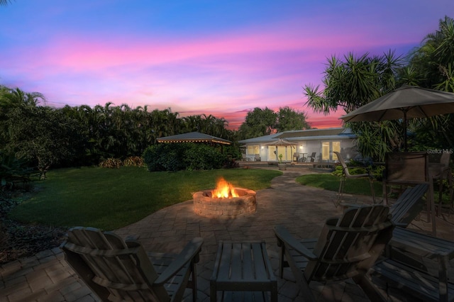 patio terrace at dusk with a yard and a fire pit