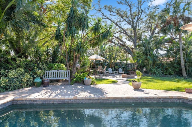 view of swimming pool with a yard, a patio, and an outdoor fire pit