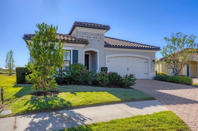 mediterranean / spanish-style house featuring a garage and a front lawn