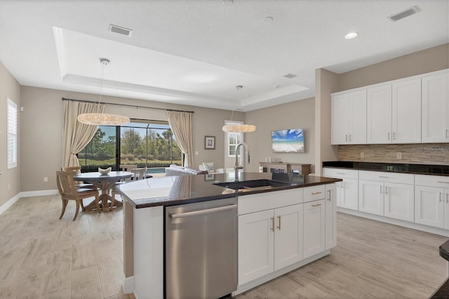 kitchen with dishwasher, a raised ceiling, sink, and hanging light fixtures