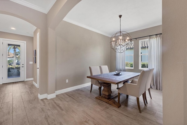 dining area with plenty of natural light, ornamental molding, a notable chandelier, and light wood-type flooring