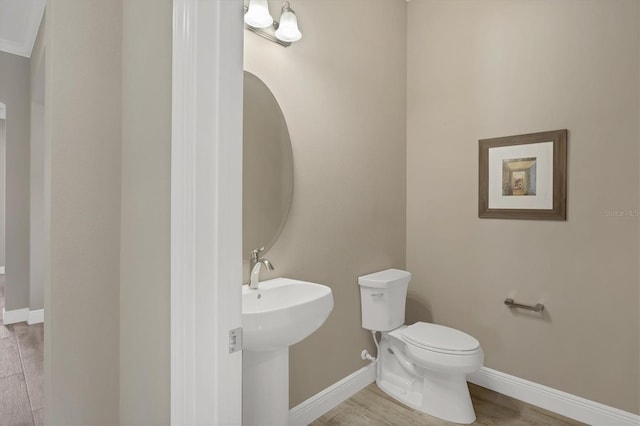 bathroom featuring sink, hardwood / wood-style floors, and toilet