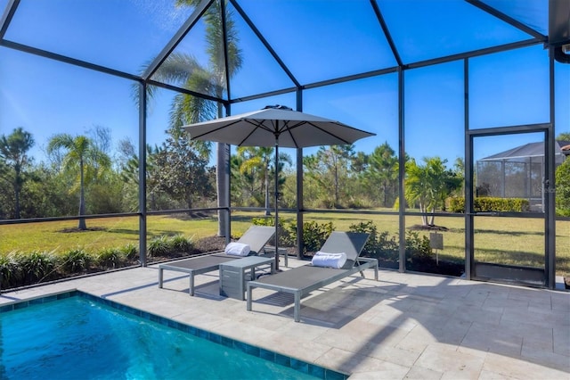 view of swimming pool featuring a lawn, a patio area, and a lanai