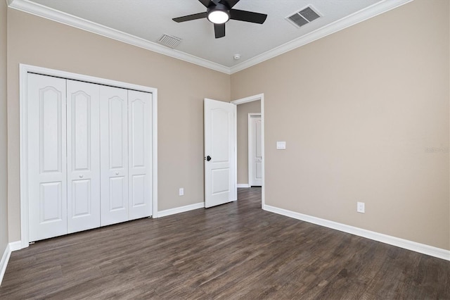 unfurnished bedroom with a closet, dark hardwood / wood-style floors, ceiling fan, and crown molding