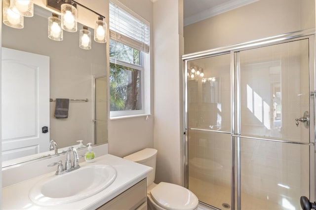 bathroom with crown molding, a shower with door, vanity, and toilet