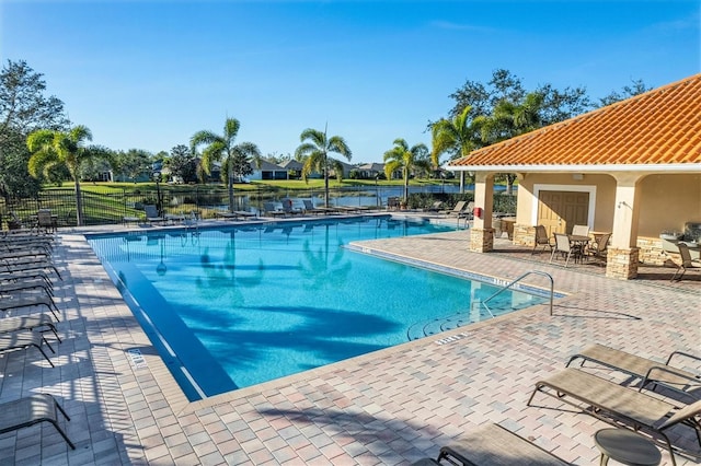 view of swimming pool with a patio area and a water view