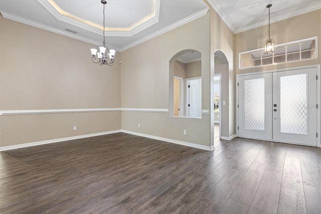 foyer featuring a tray ceiling, crown molding, dark hardwood / wood-style flooring, and a notable chandelier