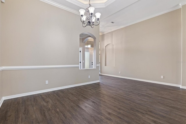 spare room featuring dark hardwood / wood-style flooring, crown molding, a tray ceiling, and a chandelier