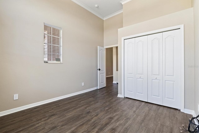 unfurnished bedroom with a closet, dark hardwood / wood-style floors, and ornamental molding