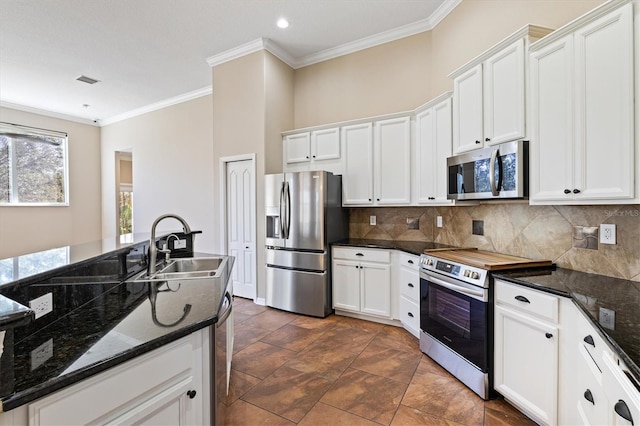 kitchen featuring white cabinets, decorative backsplash, dark stone countertops, and stainless steel appliances