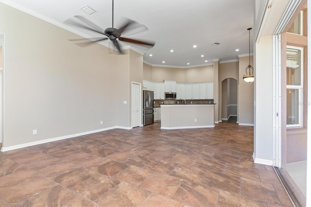 unfurnished living room with ceiling fan, ornamental molding, and sink