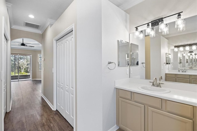 bathroom featuring hardwood / wood-style floors, vanity, ceiling fan, and ornamental molding