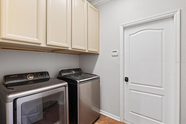 laundry room featuring cabinets, independent washer and dryer, and ornamental molding