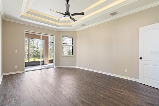 spare room featuring ceiling fan, dark hardwood / wood-style flooring, a raised ceiling, and crown molding