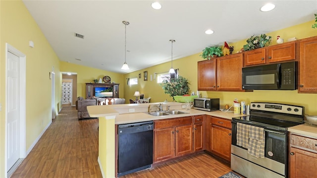 kitchen featuring black appliances, sink, kitchen peninsula, and dark wood-type flooring