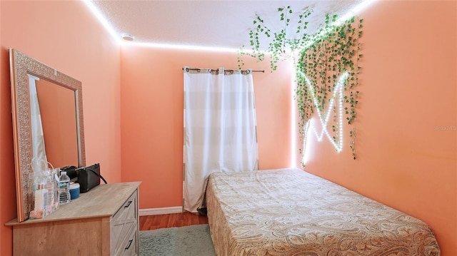 bedroom with a textured ceiling and light hardwood / wood-style floors