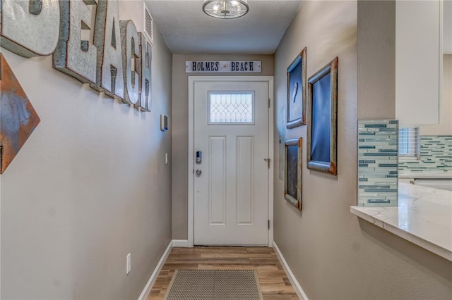 entryway featuring a textured ceiling and light hardwood / wood-style floors