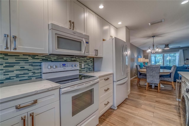 kitchen featuring light hardwood / wood-style floors, ceiling fan with notable chandelier, white cabinetry, and white appliances