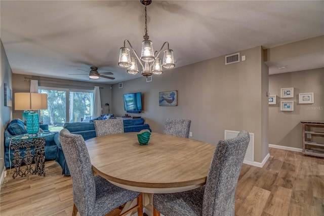 dining space featuring light hardwood / wood-style floors and ceiling fan with notable chandelier